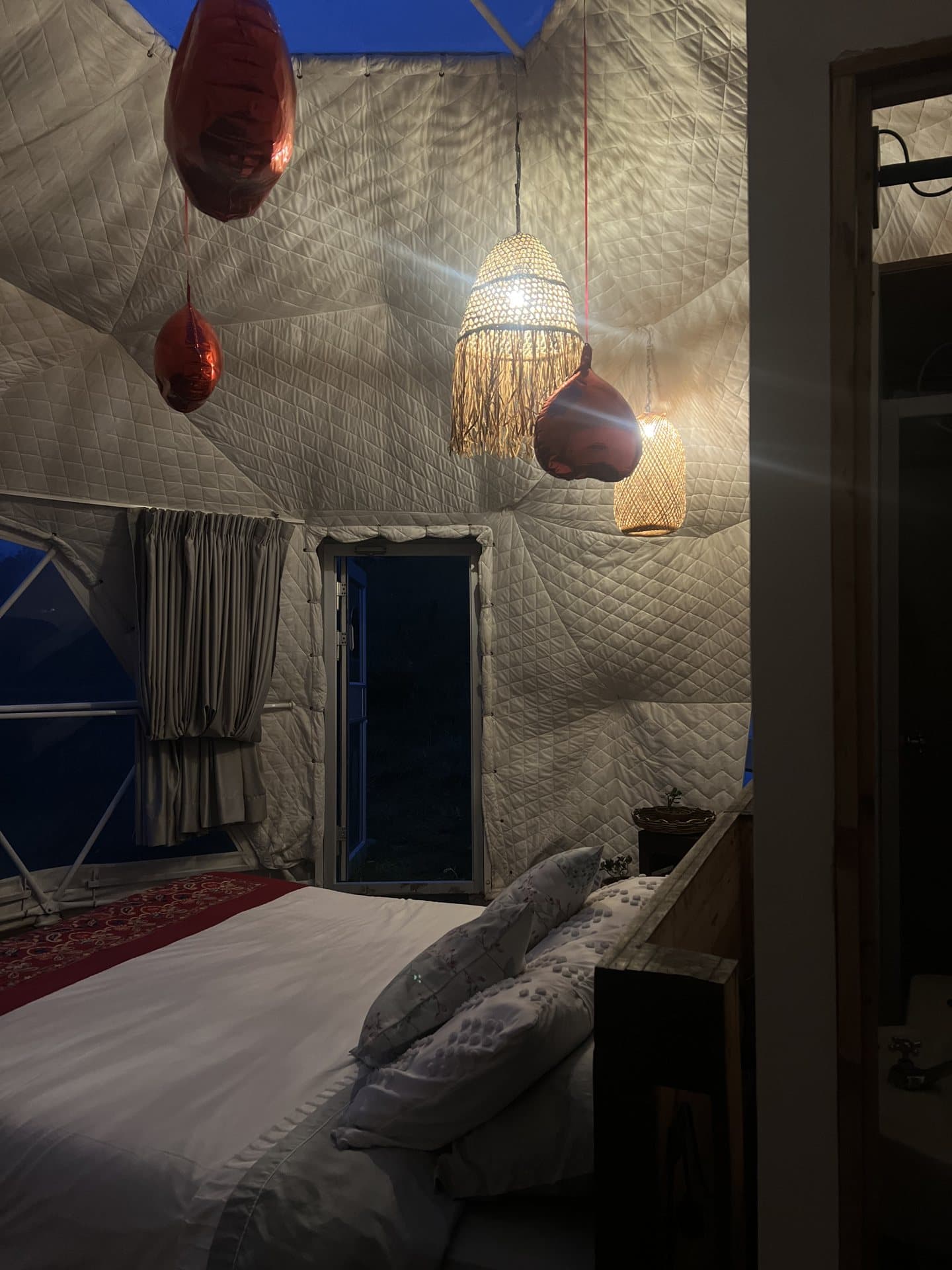 Domo Aire de Nómada Glamping iluminado al anochecer